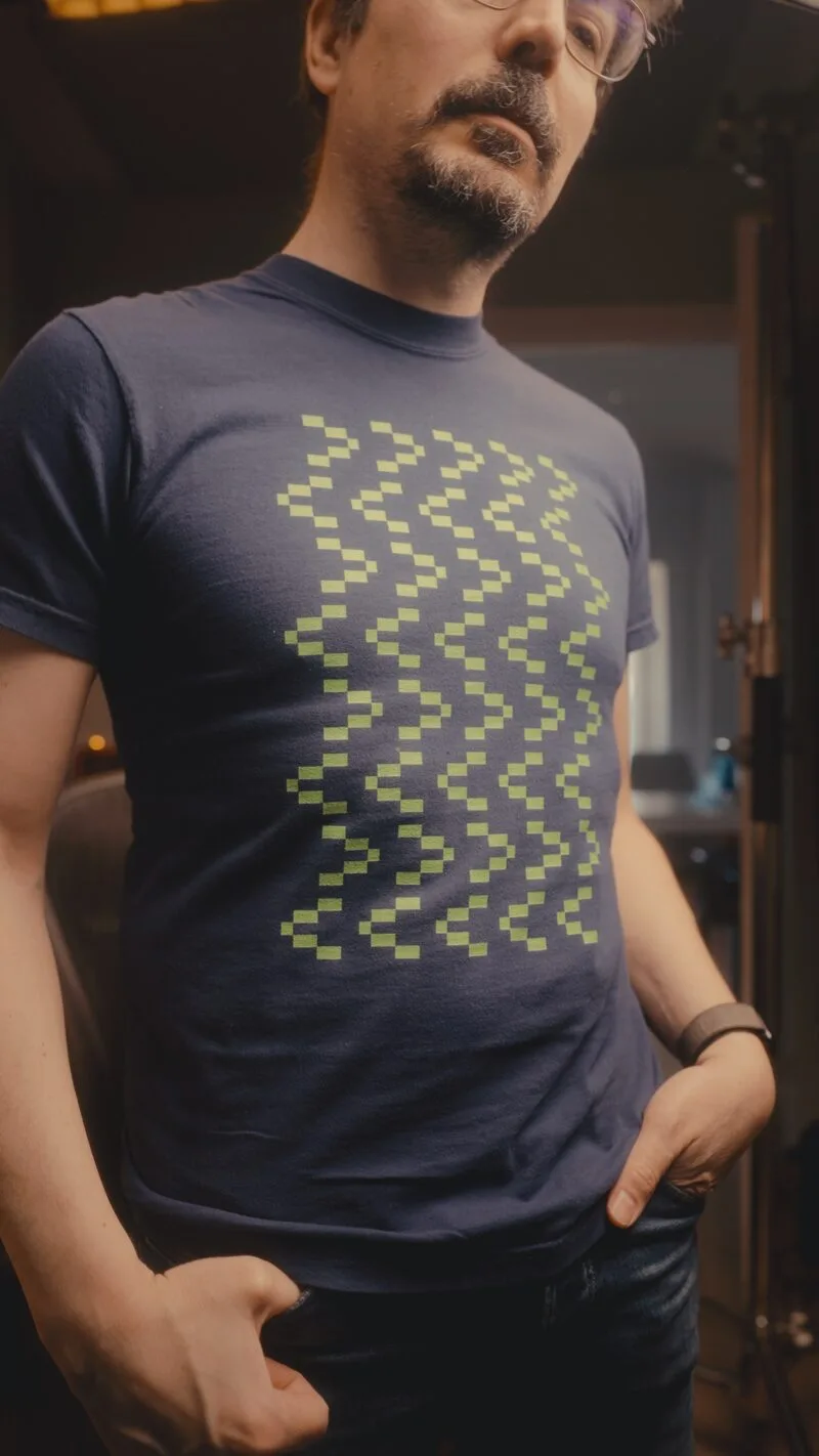 A black Wasabi T-shirt with a green pixel cat design.